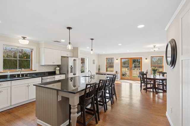 kitchen featuring dark countertops, wood finished floors, stainless steel appliances, and a sink