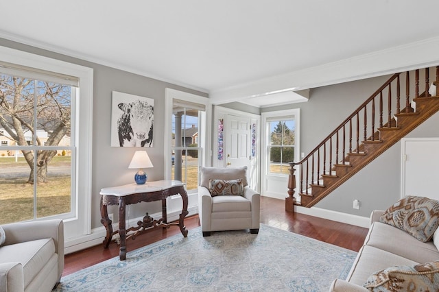 sitting room with stairway, ornamental molding, baseboards, and wood finished floors