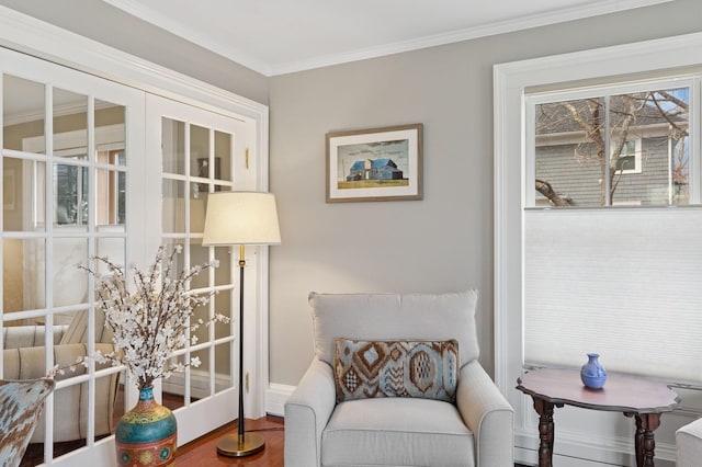 sitting room with wood finished floors, baseboards, and ornamental molding