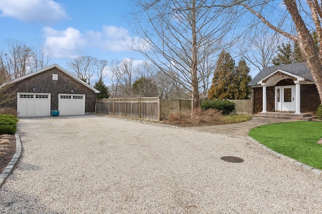 exterior space featuring a detached garage and a fenced front yard