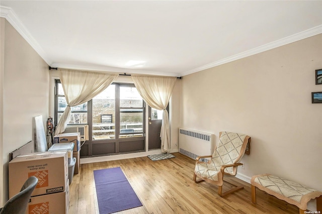 living area featuring light wood-style flooring, radiator heating unit, ornamental molding, cooling unit, and baseboards