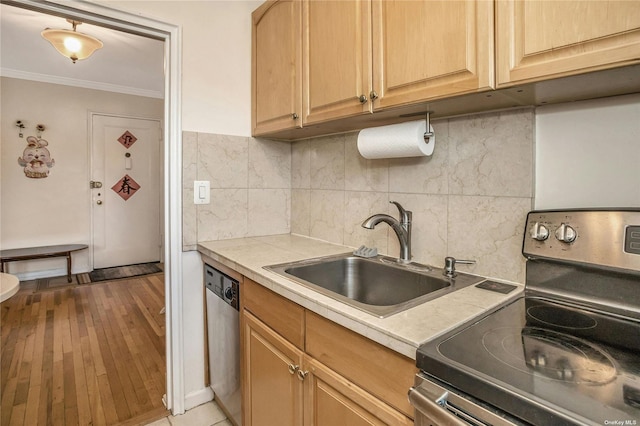 kitchen with decorative backsplash, stainless steel appliances, crown molding, light countertops, and a sink