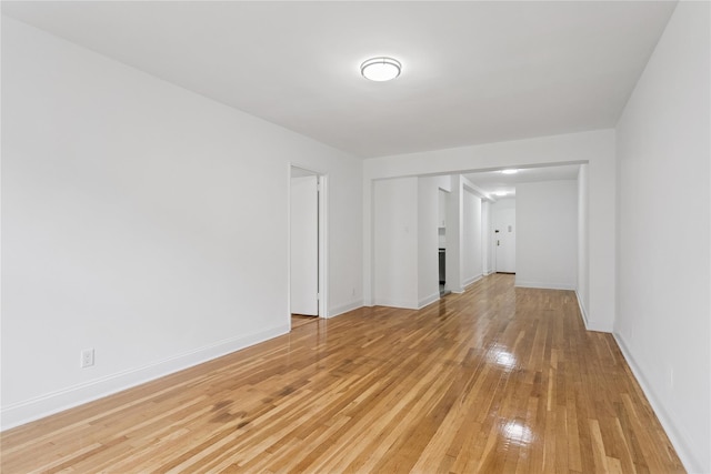 spare room featuring light wood finished floors and baseboards