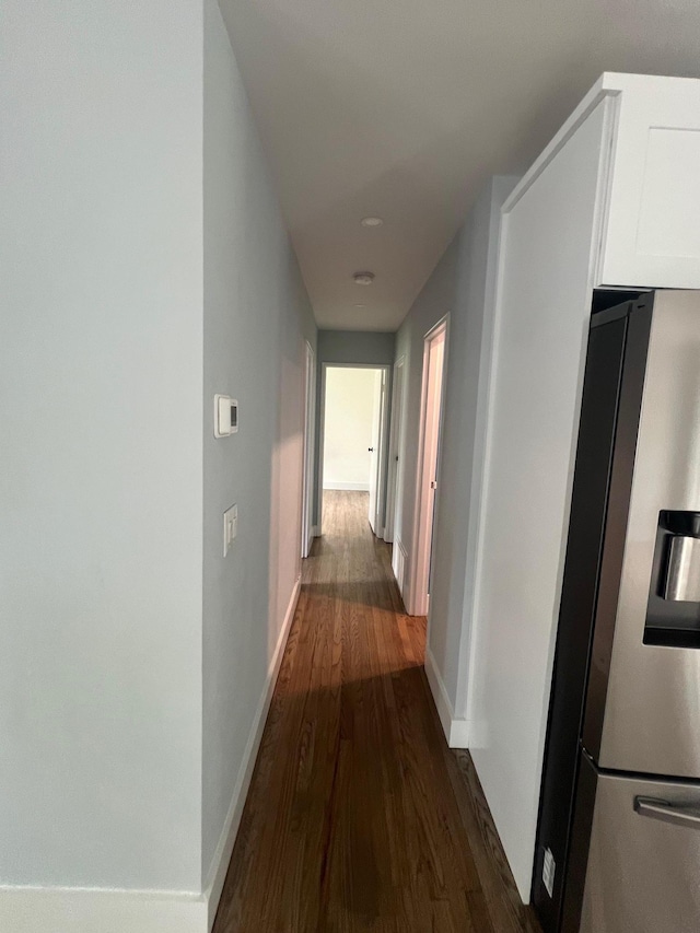 hall with dark wood-style floors and baseboards