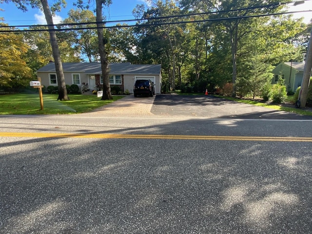 view of front of home with concrete driveway, a garage, and a front yard