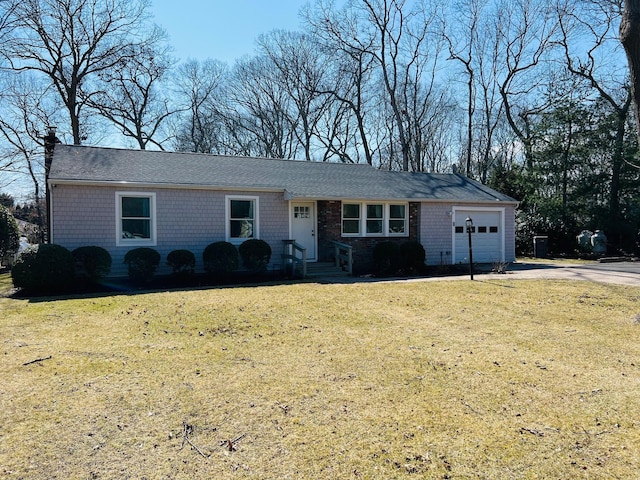 ranch-style home with driveway, a front yard, a chimney, and an attached garage