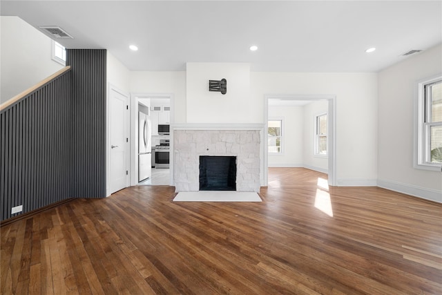 unfurnished living room with hardwood / wood-style floors, a fireplace, visible vents, and recessed lighting