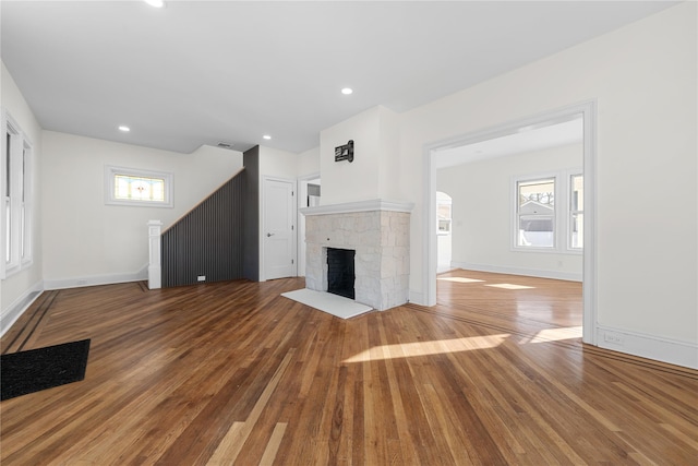 unfurnished living room featuring a fireplace, baseboards, and hardwood / wood-style flooring