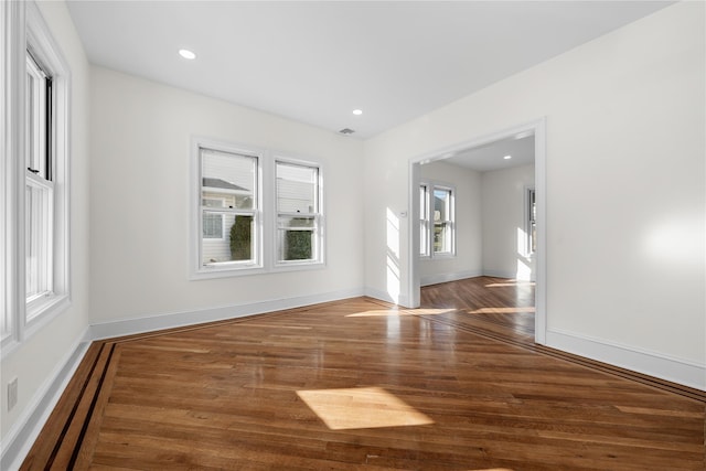 spare room with recessed lighting, wood finished floors, visible vents, and baseboards