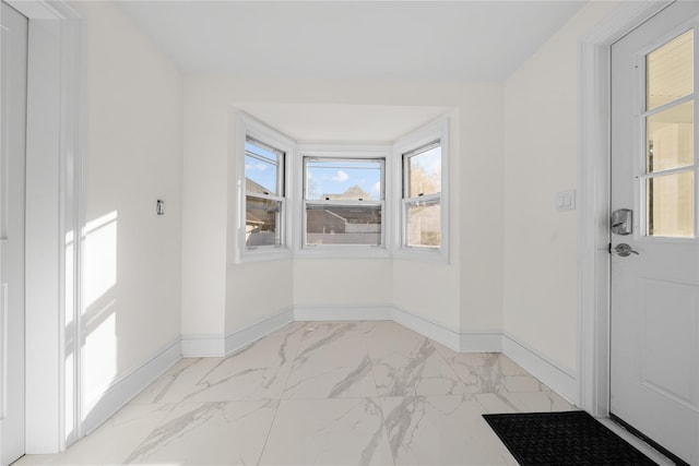 interior space with marble finish floor and baseboards