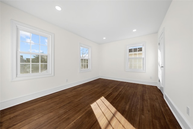 empty room with baseboards, dark wood-style flooring, and recessed lighting