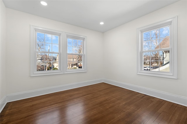 spare room featuring baseboards, dark wood-type flooring, and recessed lighting