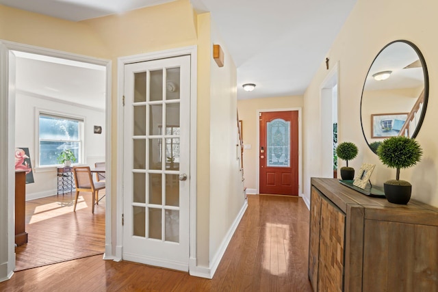 foyer with baseboards and hardwood / wood-style flooring