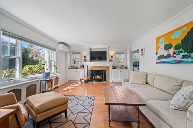 living room with a wall unit AC, plenty of natural light, wood finished floors, and ornamental molding