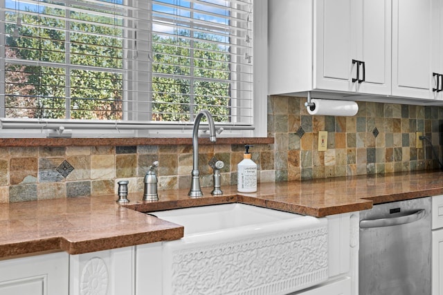 kitchen with dark stone counters, a sink, decorative backsplash, white cabinets, and stainless steel dishwasher