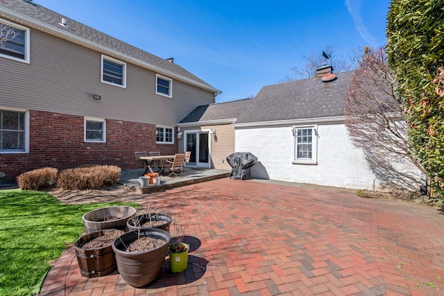 rear view of property with a yard, a patio, and a shingled roof