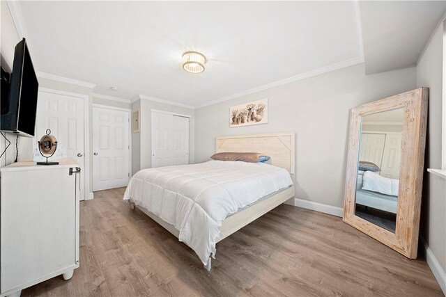 bedroom featuring ornamental molding, a closet, baseboards, and light wood finished floors