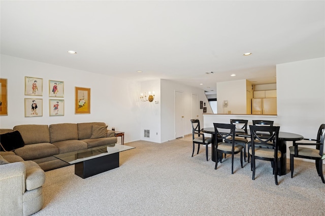 living area featuring visible vents, recessed lighting, and light colored carpet