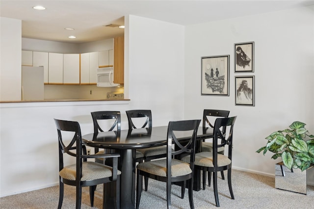 dining space featuring recessed lighting, baseboards, and light carpet