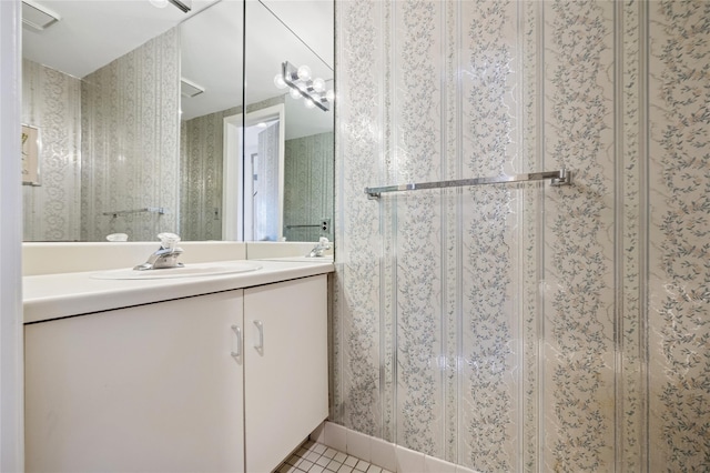 bathroom featuring wallpapered walls, tile patterned floors, an enclosed shower, and vanity