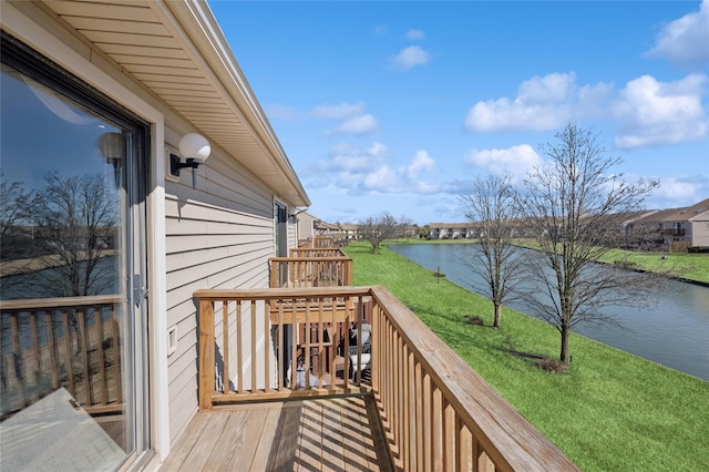 wooden terrace with a yard and a water view