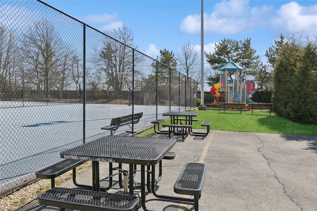 view of home's community with community basketball court, a lawn, playground community, and fence