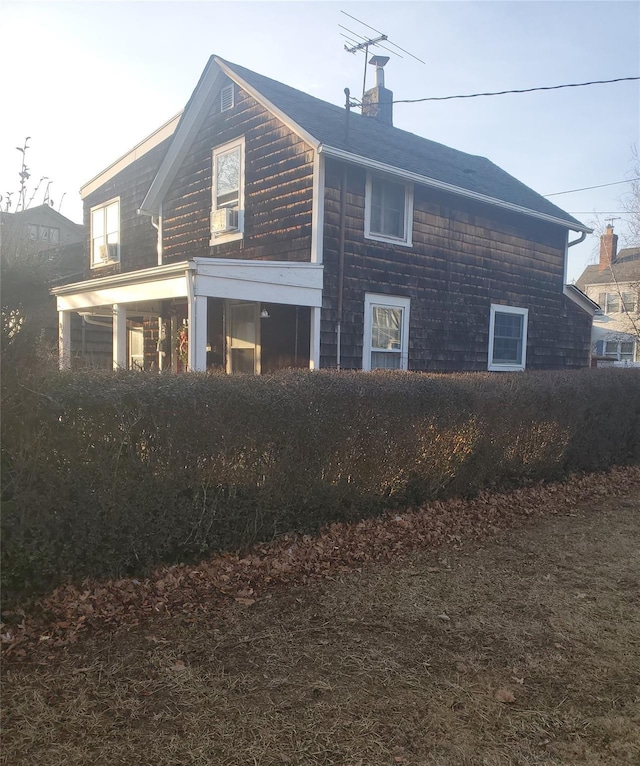 view of side of property featuring a chimney and cooling unit