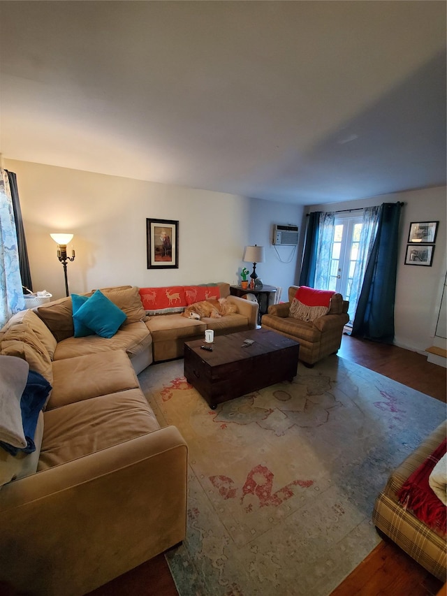 living room featuring an AC wall unit, wood finished floors, and french doors