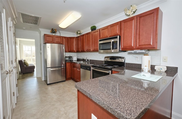 kitchen featuring visible vents, appliances with stainless steel finishes, ornamental molding, a peninsula, and a sink