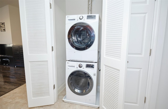 laundry room featuring laundry area, tile patterned flooring, and stacked washer / drying machine