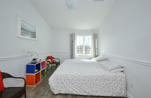 bedroom featuring lofted ceiling and wood finished floors