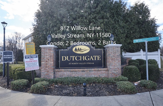 community / neighborhood sign featuring fence