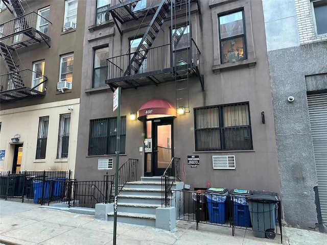 doorway to property with fence and cooling unit