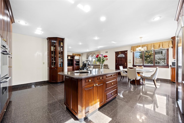 kitchen with granite finish floor, baseboards, and a sink