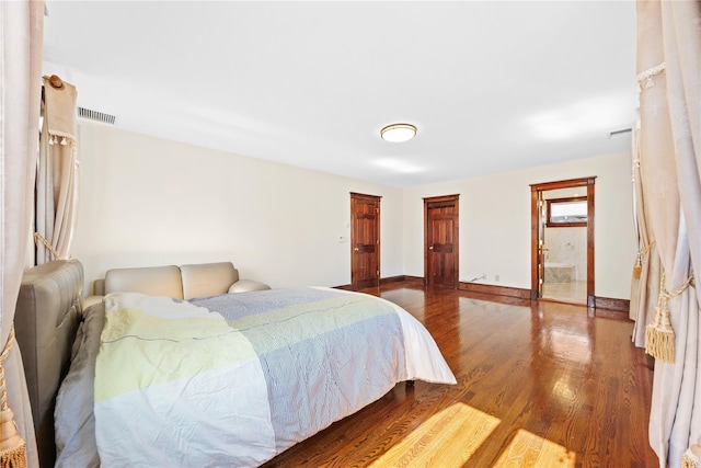 bedroom with dark wood finished floors, visible vents, and baseboards