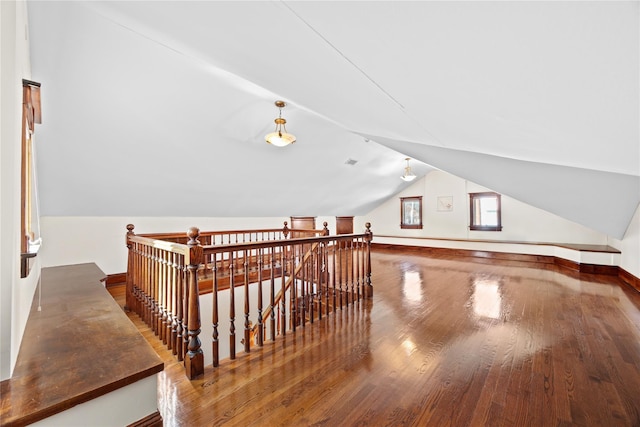 additional living space with vaulted ceiling, hardwood / wood-style flooring, and baseboards