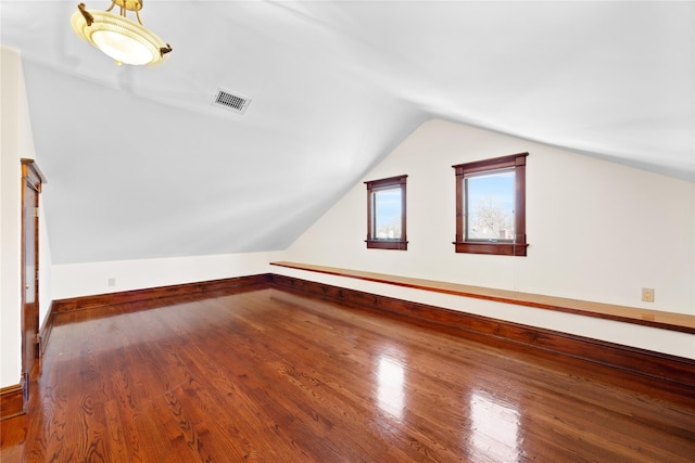 bonus room featuring lofted ceiling, visible vents, and wood finished floors