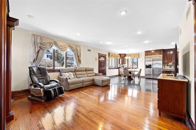 living room featuring recessed lighting, wood-type flooring, and baseboards