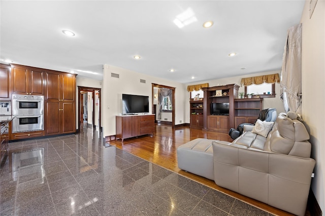 living room with recessed lighting, visible vents, granite finish floor, and baseboards