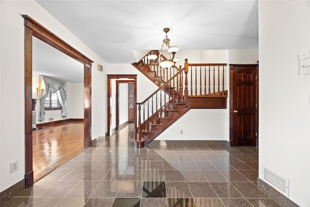 entrance foyer featuring granite finish floor, stairs, visible vents, and baseboards