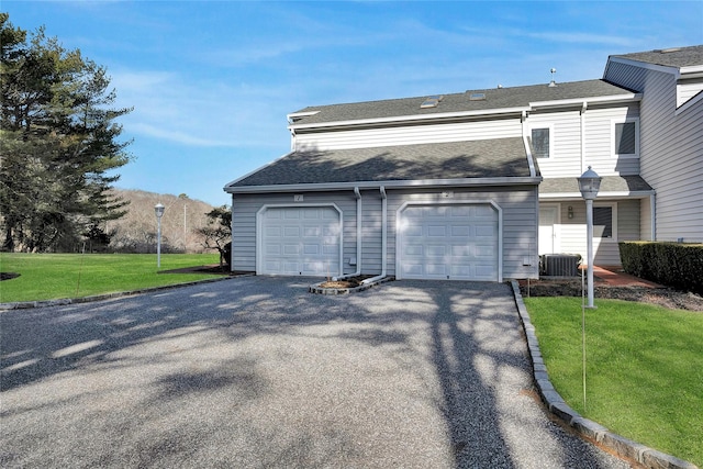 view of property featuring a front lawn, driveway, central AC, and roof with shingles