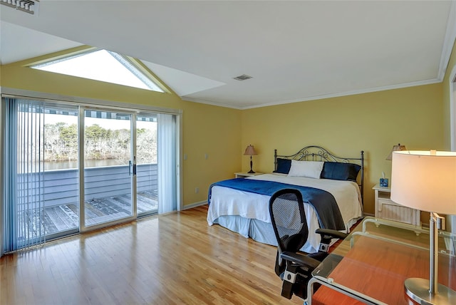 bedroom featuring access to exterior, visible vents, light wood-style floors, and vaulted ceiling