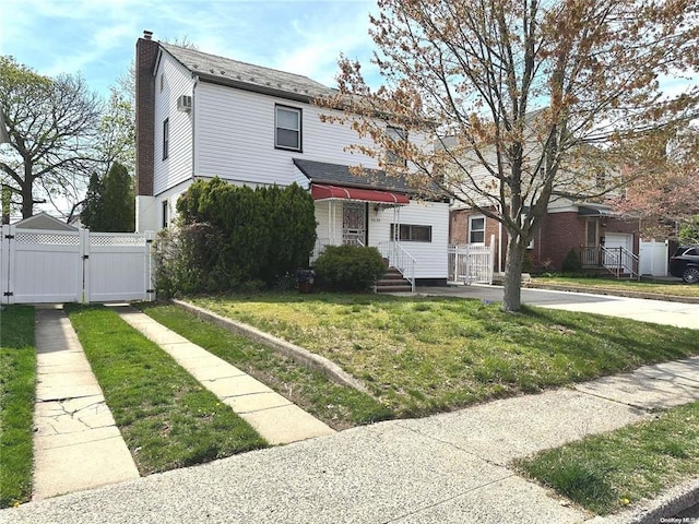 view of front of property featuring a shingled roof, a chimney, a gate, fence, and a front lawn