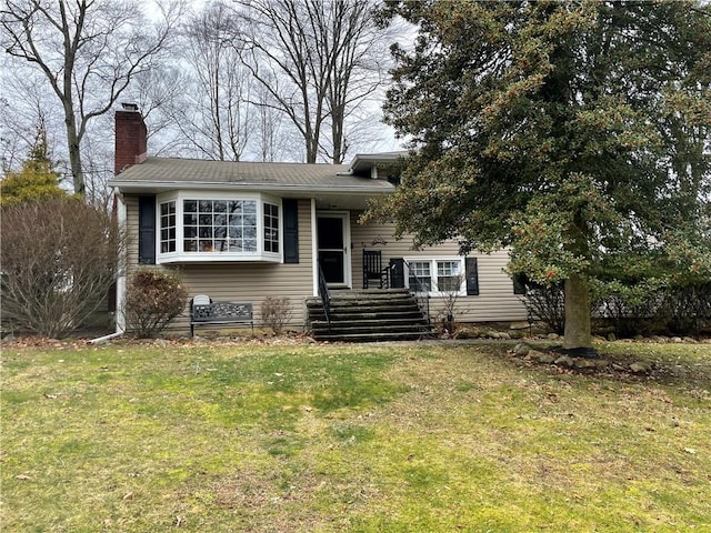 view of front of home featuring a front yard and a chimney