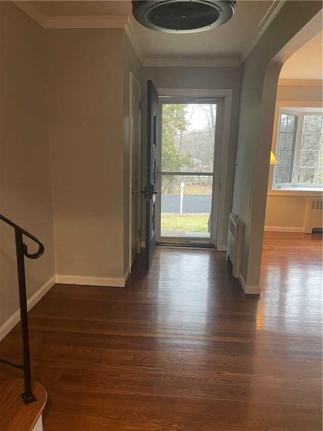 entrance foyer featuring radiator, baseboards, ornamental molding, and dark wood-style flooring