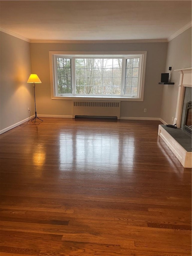 unfurnished living room with radiator heating unit, a fireplace, wood finished floors, and crown molding