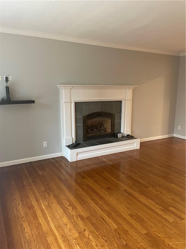 room details featuring crown molding, a fireplace, wood finished floors, and baseboards