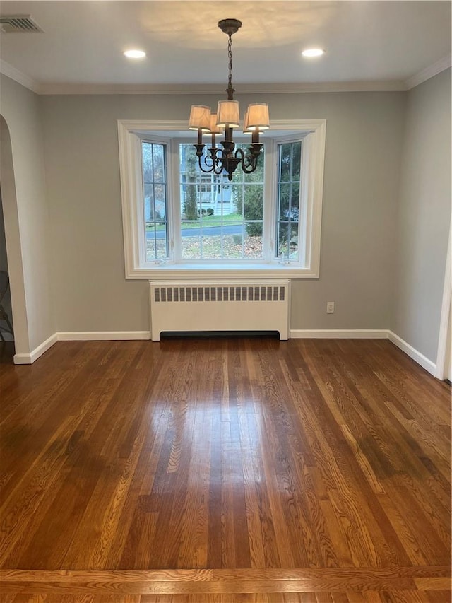 unfurnished dining area with visible vents, arched walkways, radiator, dark wood-style flooring, and crown molding