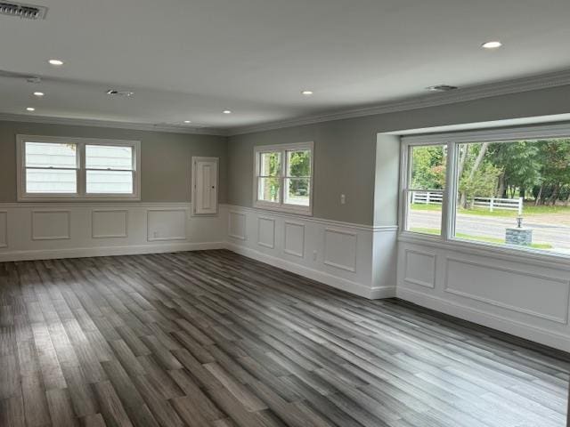 empty room featuring plenty of natural light, visible vents, dark wood finished floors, and recessed lighting