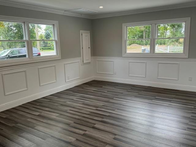 empty room with recessed lighting, a wainscoted wall, visible vents, ornamental molding, and dark wood-style floors